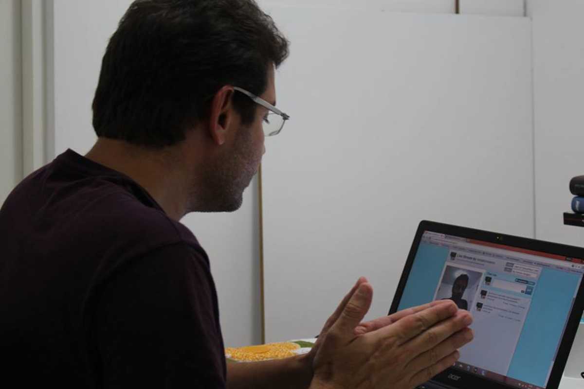 Renato Roseno diante do computador no momento do bate-papo virtual em que a imagem dele está na tela