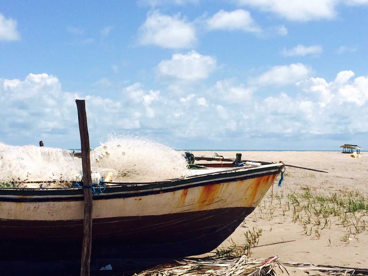 Barcos de pesca à beira-mar com o mar ao fundo