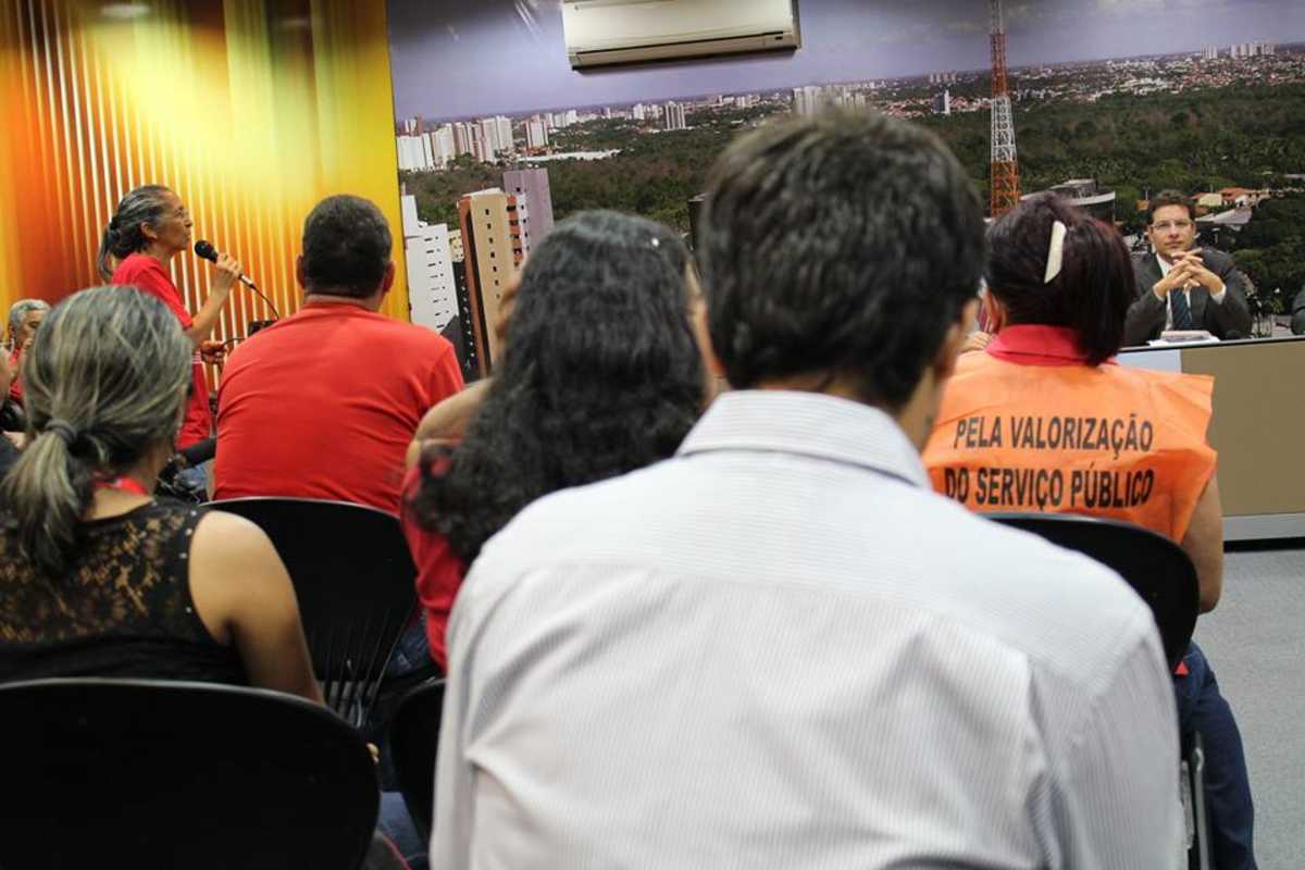 O deputado Renato Roseno, sentado e ao fundo, escuta servidores estaduais reunidos no Complexo das Comissões Técnicas da Assembleia Legislativa