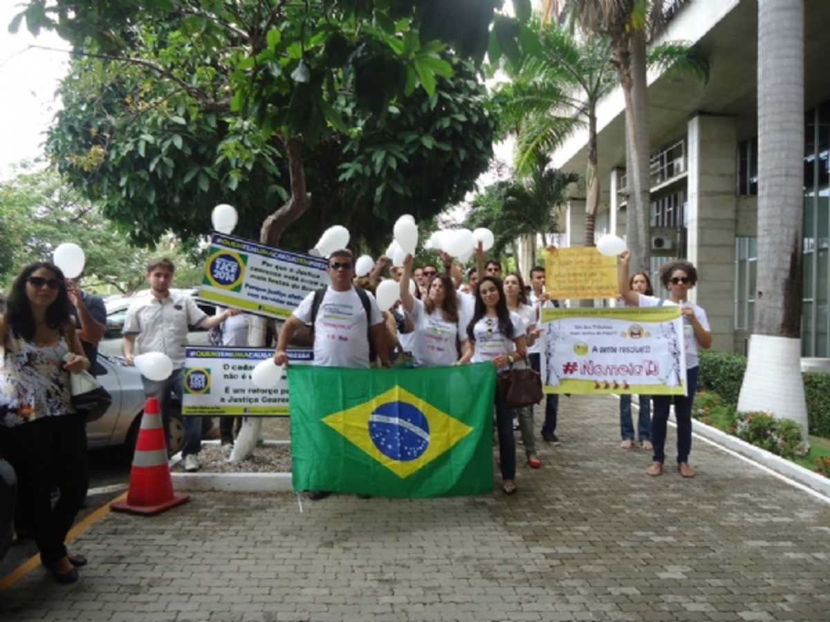 Pessoas seguram balões, faixas, cartazes e a bandeira do Brasil em manifestação diante do prédio do Tribunal de Justiça pela convocação dos aprovados em concurso