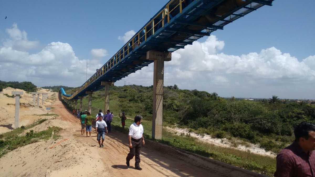 Grupo de pessoas sob a Esteira do Pecém, entre elas o deputado estadual Renato Roseno, durante visita ao elevado erguido para o transporte de carvão mineral poluente para a Companhia Siderúrgica do Pecém