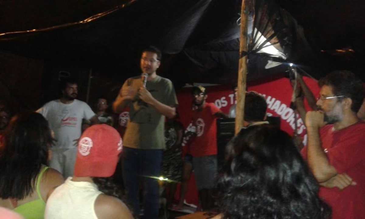 Renato Roseno fala ao microfone, dirigindo-se às pessoas que ocupam terreno em Maracanaú
