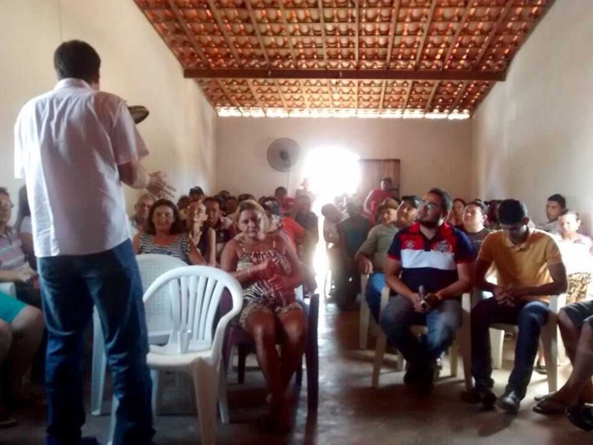 Renato Roseno, em pé, fala com moradores, sentados, da  comunidade da localidade Sítio Lagoa Nova, em Senador Pompeu