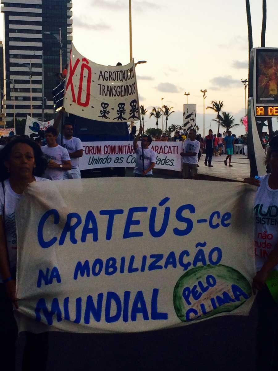Manifestantes expõem faixas durante Mobilização Mundial pelo Clima, em caminhada pela Avenida Beira Mar