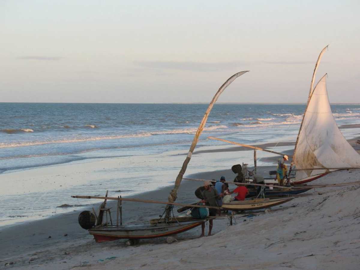 Praia com jangadas e jangadeiros à beira-mar