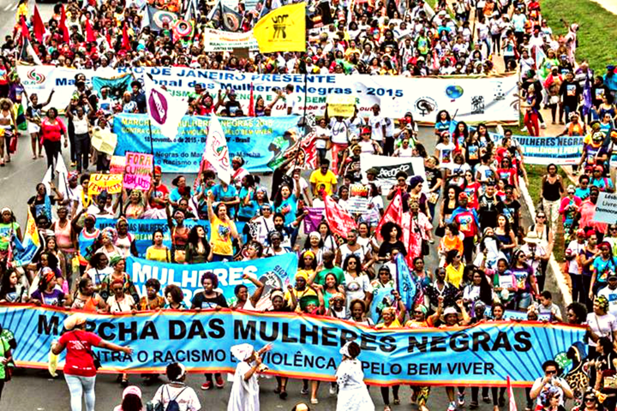 Mulheres negras carregam faixas e cartazes em caminhada rumo ao Congresso Nacional