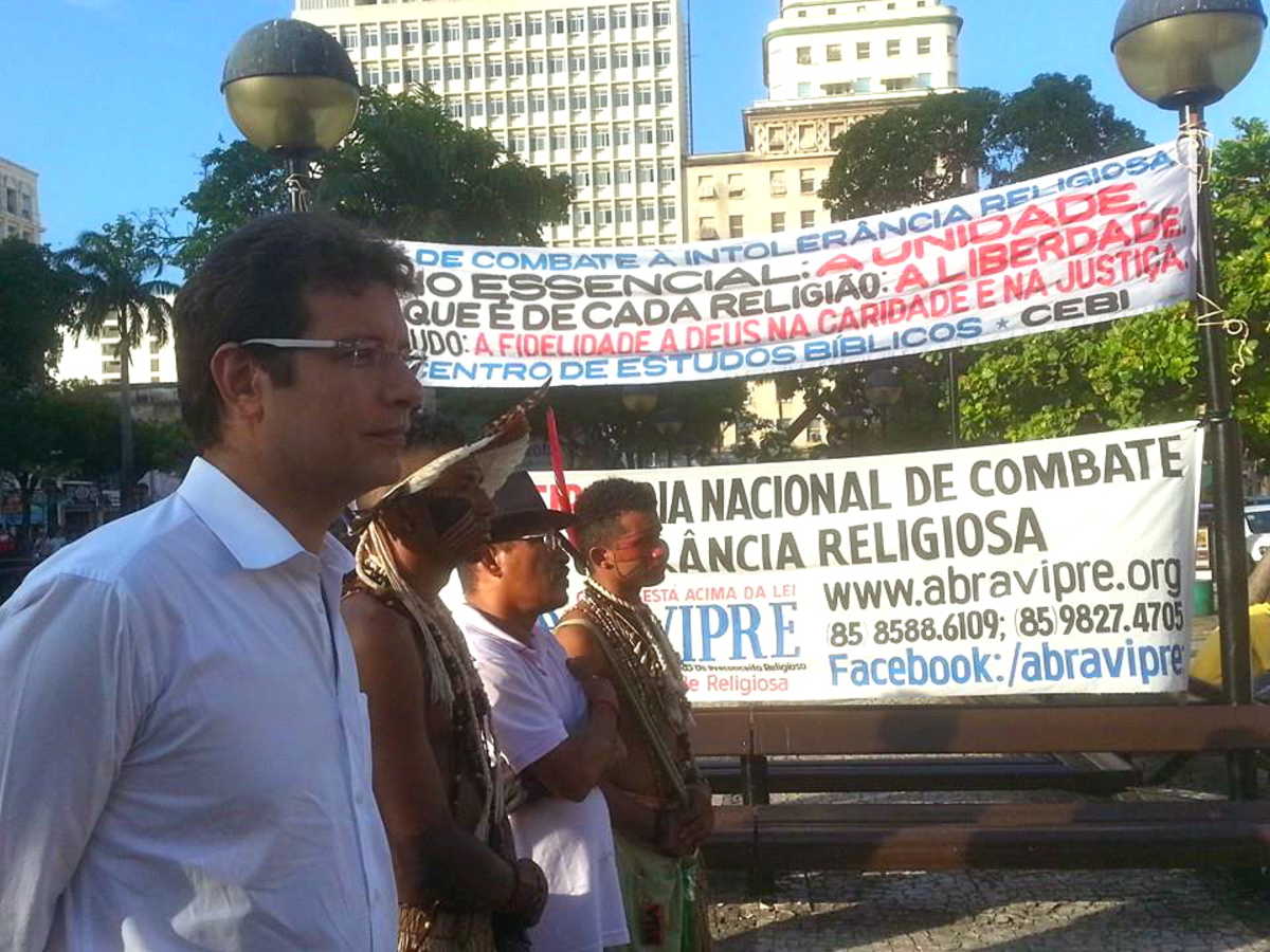 Renato Roseno, ao lado de indígenas e militantes do movimento negro, na Praça do Ferreira, em Fortaleza, com faixas ao fundo pregando a liberdade religiosa