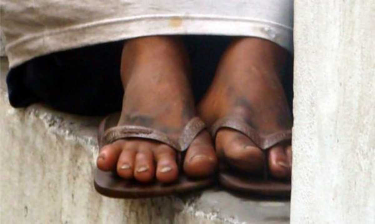 Em detalhe os pés sujos de uma criança que vive pelas ruas