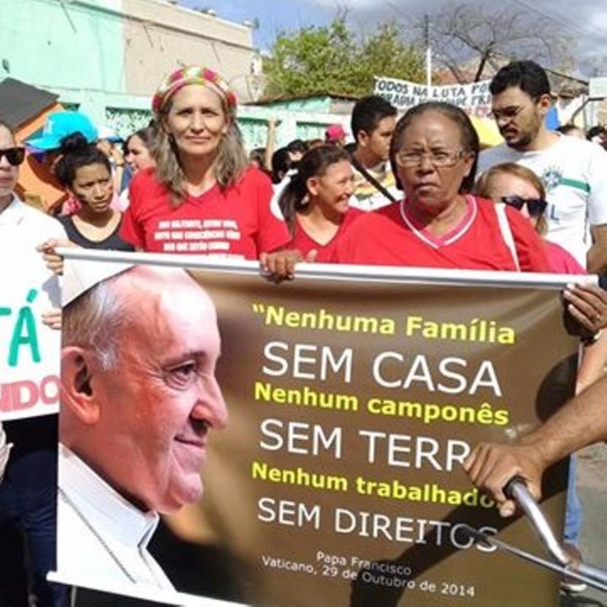 Pessoas em passeata pela rua, segundo um cartaz