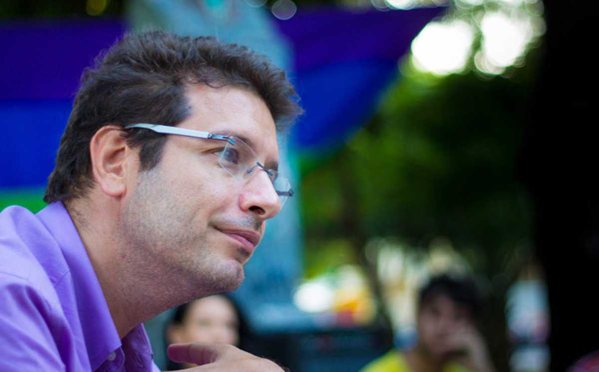 Renato Roseno, de perfil, conversa com jovens em praça pública