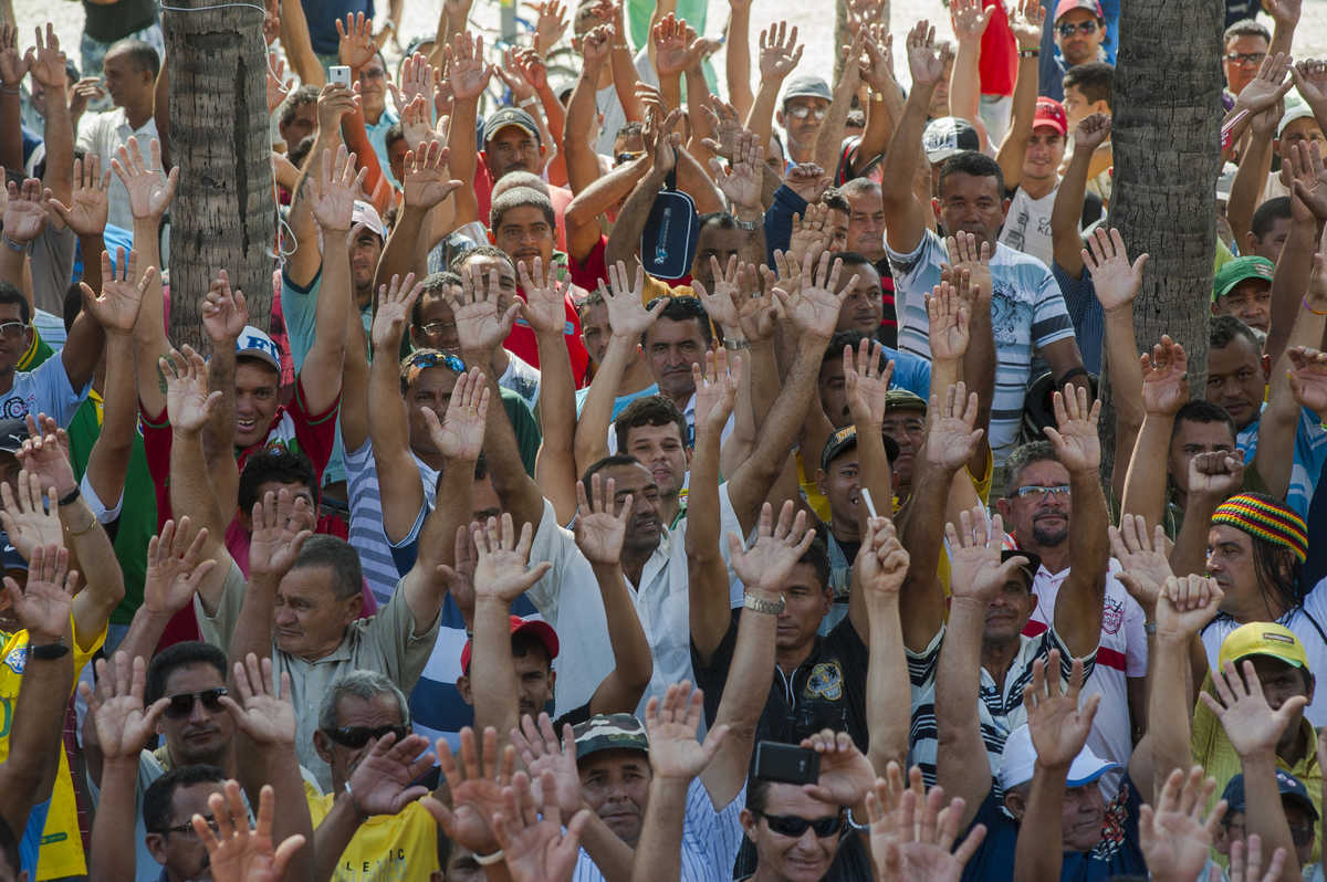 Dezenas de trabalhadores com as mãos para o alto