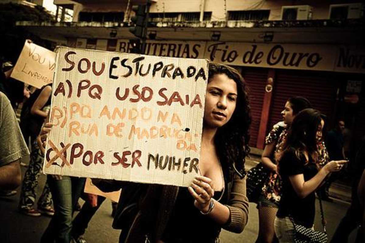 Mulher segura cartaz em manifestação pública com os dizeres 